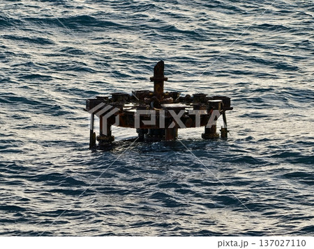 Abandoned maritime ruin, Desolate steel structure drifting on rough seas with barnacles and peeling paint 137027110