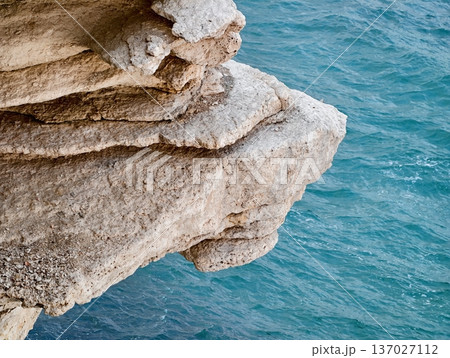 Coastal limestone with weathered textures, Sunlit cliffs and turquoise waters create scenic backdrop Coastal limestone with weathered textures, Sunlit cliffs and turquoise waters create scenic backdrop 137027112