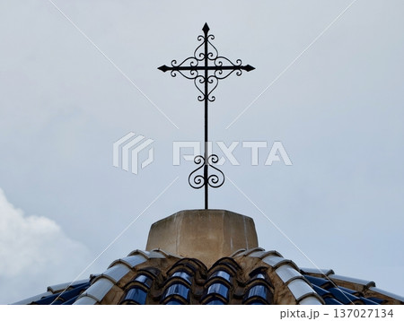 Decorative cross above lively city with colorful domes and preserved historic craftsmanship 137027134