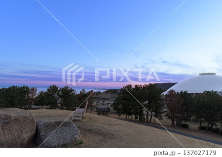 夕焼けの海とドームが見える公園の丘の風景 137027179
