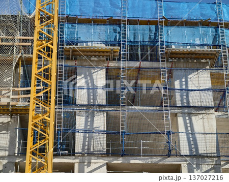 Industrial facade with safety equipment, Building front with scaffolding and protective nets 137027216