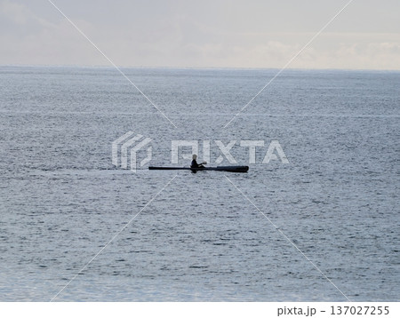 Serene kayaking during sunset, Solitary paddling across gentle ocean waves under fading light of day Serene kayaking during sunset, Solitary paddling across gentle ocean waves under fading light of day 137027255