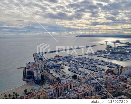 Coastal port with boats and clouds, Aerial view of bustling port including marina and cloudy sky Coastal port with boats and clouds, Aerial view of bustling port including marina and cloudy sky 137027290