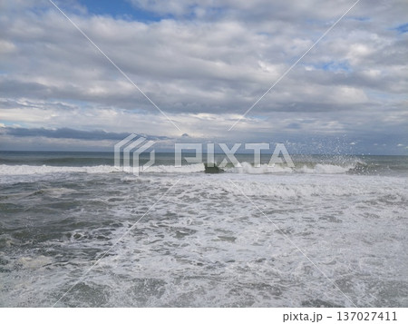 Peaceful ocean waves, Calm sea flows toward horizon, Serene waters ripple beneath cloudy sky Peaceful ocean waves, Calm sea flows toward horizon, Serene waters ripple beneath cloudy sky 137027411