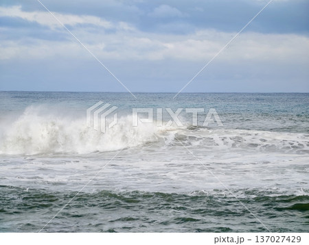Turbulent sea sparkles beneath flickering light, Agitated ocean sparkles as darkness and storm collide 137027429