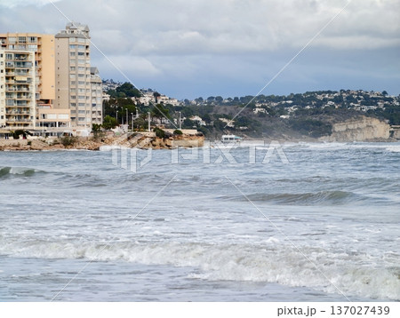 Luxury rooftop dwellings offering panoramic views of crashing waves and vibrant city lights 137027439