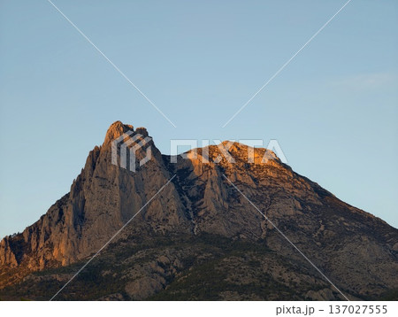 Early morning sunlight highlights jagged ridge lines perfect for outdoor adventure planning and promotion 137027555