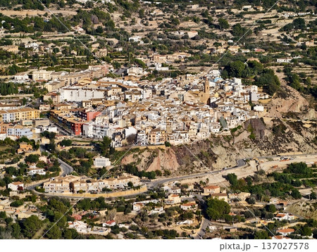 Landscape with rugged cliffs surrounds settlement, Settlement nestled among ochre slopes and cliffs 137027578