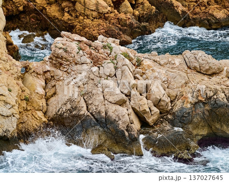 Stormy sea surge, Rough ocean strikes jagged coast, Chaotic waves collide with rugged shoreline rocks Stormy sea surge, Rough ocean strikes jagged coast, Chaotic waves collide with rugged shoreline rocks 137027645
