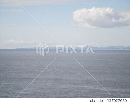 Relaxing open ocean landscape with single drifting cloud illuminated softly for meditative ambiance Relaxing open ocean landscape with single drifting cloud illuminated softly for meditative ambiance 137027680