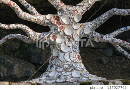 A tree whose bark is made from mosaic fragments of old patterned ceramic cups. The trunk looks like an artifact. Surrealism. 137027761