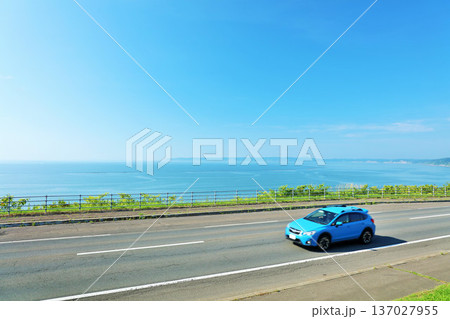 北海道　青空と海沿いの道を走る車 137027955