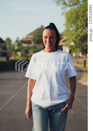 Smiling Mature Scandinavian Tourist Woman Walking Outdoors on Summer Holiday 137028993