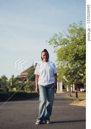 Smiling Mature Scandinavian Tourist Woman Walking Outdoors on Summer Holiday 137028995