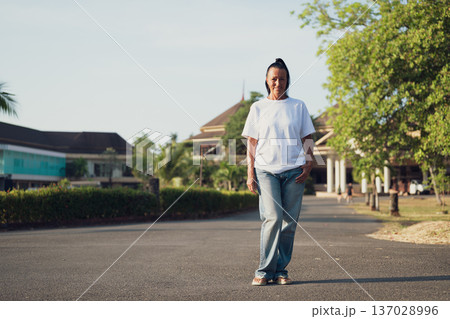 Smiling Mature Scandinavian Tourist Woman Walking Outdoors on Summer Holiday Smiling Mature Scandinavian Tourist Woman Walking Outdoors on Summer Holiday 137028996