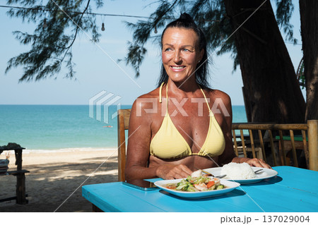 Active senior woman enjoying seafood and rice at seaside restaurant in Thailand cafe restaurant Active senior woman enjoying seafood and rice at seaside restaurant in Thailand cafe restaurant 137029004