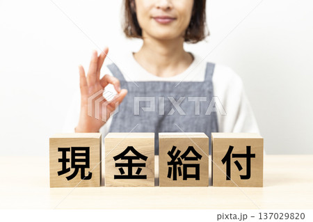 「現金給付」と書かれたブロックとエプロン姿の女性 「現金給付」と書かれたブロックとエプロン姿の女性 137029820