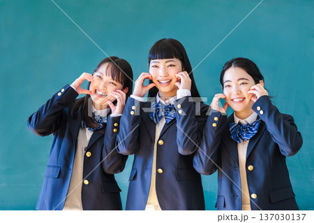 黒板の前で友達とポーズをとる女子高生 137030137