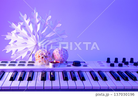 Christmas background with midi keyboard and holiday decor with neon lights. Christmas background with midi keyboard and holiday decor with neon lights. 137030196