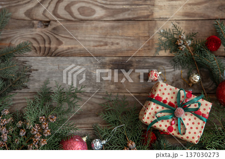 Festive Christmas background with a gift box on a wooden surface. Festive Christmas background with a gift box on a wooden surface. 137030273