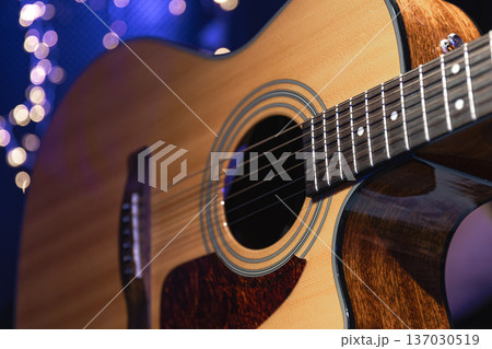 Close-up, acoustic guitar on a dark background with bokeh lights. 137030519