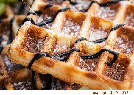 Close-up, appetizing Belgian waffles drizzled with chocolate. Close-up, appetizing Belgian waffles drizzled with chocolate. 137030522