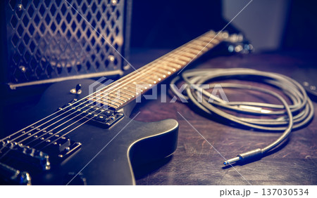 Close-up, black electric guitar on a dark background. 137030534