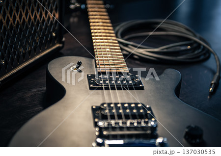 Close-up, black electric guitar on a dark background. 137030535