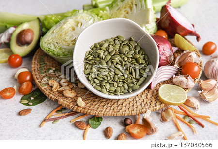 Close-up, a bowl of pumpkin seeds and other healthy foods on the kitchen table. Close-up, a bowl of pumpkin seeds and other healthy foods on the kitchen table. 137030566