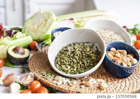 Close-up, a bowl of pumpkin seeds and other healthy foods on the kitchen table. Close-up, a bowl of pumpkin seeds and other healthy foods on the kitchen table. 137030568