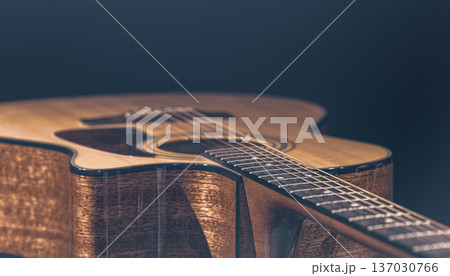 Close-up of a classical acoustic guitar on a black background. 137030766