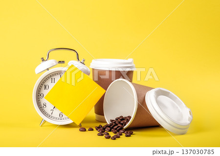 Alarm clock, paper cup, paper reminder and coffee beans on yellow background. 137030785
