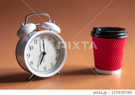 Alarm clock and paper disposable cup of coffee. 137030789