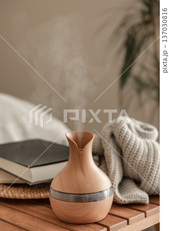 Aroma oil diffuser lamp on a blurred background in the interior of the room. Aroma oil diffuser lamp on a blurred background in the interior of the room. 137030816