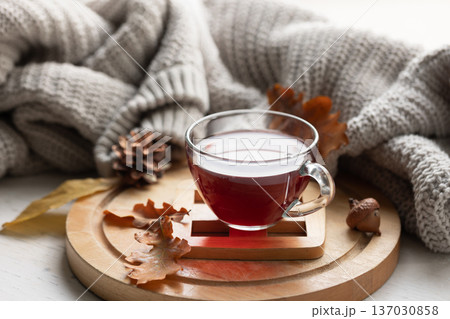 Autumn composition with a cup of tea, leaves and a knitted element. 137030858