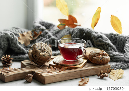 Autumn still life with a cup of tea, cookies and a knitted item. Autumn still life with a cup of tea, cookies and a knitted item. 137030894