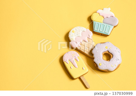 Colorful glazed gingerbread cookies on yellow background copy space. Colorful glazed gingerbread cookies on yellow background copy space. 137030999