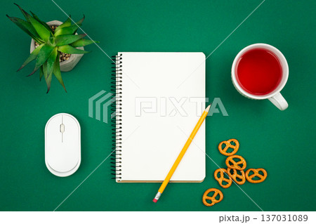 Blank notebook, cup of tea and pretzels on green background, flat lay. Blank notebook, cup of tea and pretzels on green background, flat lay. 137031089