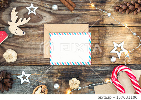 Blank paper, envelope and Christmas decor on wooden background, copy space. Blank paper, envelope and Christmas decor on wooden background, copy space. 137031100