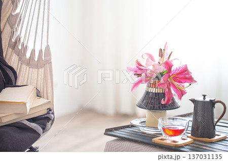 A hammock chair with Cup of tea and beautiful Lily flowers. 137031135
