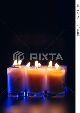 Burning candle on black background with backlight. Memorial Day. Burning candle on black background with backlight. Memorial Day. 137031236