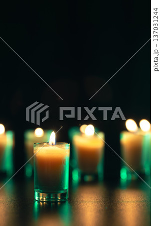 Burning candle on black background with backlight. Memorial Day. Burning candle on black background with backlight. Memorial Day. 137031244