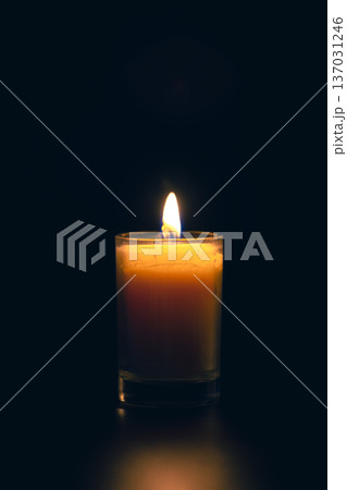 Burning candle on black background with backlight. Memorial Day. 137031246