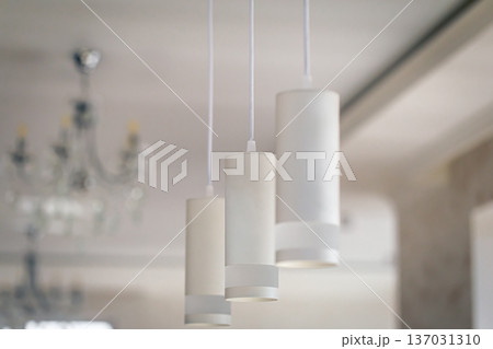 Chandelier in the interior of the room, lamps in white shades. Chandelier in the interior of the room, lamps in white shades. 137031310