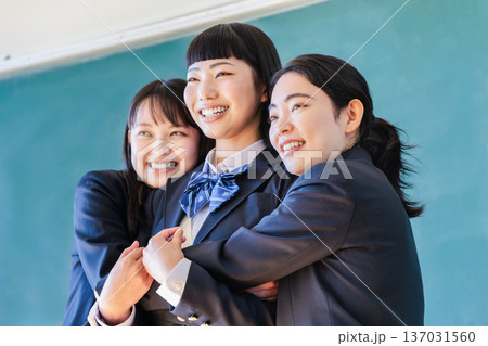 黒板の前で友達とポーズをとる女子高生 137031560