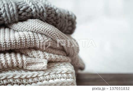 A stack of warm knitted items on blurred white background copy space. A stack of warm knitted items on blurred white background copy space. 137031832
