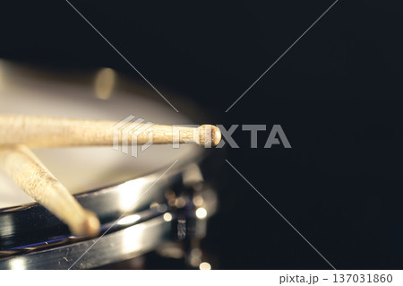 Close-up, snare drum and drumsticks on a dark background. 137031860