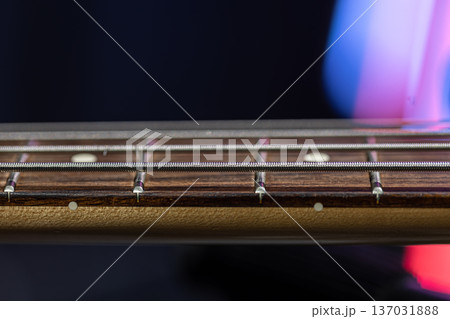 Close-up of strings on the fretboard of a bass guitar. Close-up of strings on the fretboard of a bass guitar. 137031888