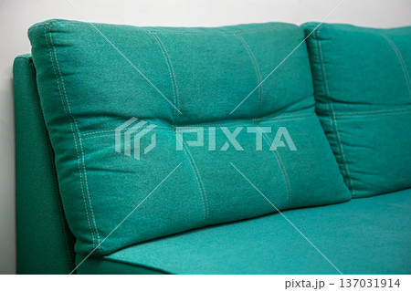 Closeup of turquoise sofa with large pillows. 137031914