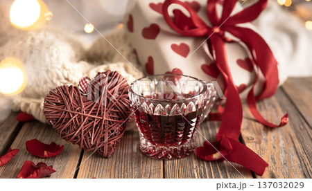 A composition for Valentine's Day with a red drink, a gift and decor details. 137032029